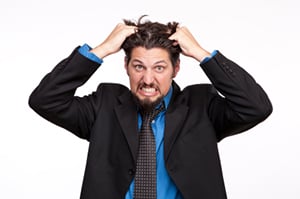Frustrated young businessman pulling his hair